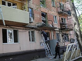Zam�stnanci m�stské správy pracují na míst� bytového domu zasa�eného ruským...