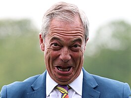 P�edseda britské strany Reform UK Nigel Farage reaguje p�i setkání s nov�...
