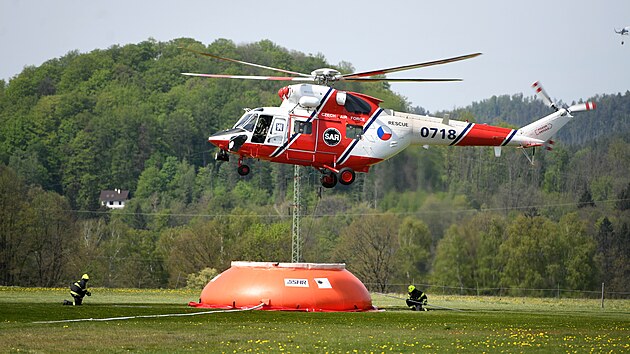 Po��r lesa v �esk�m �v�carsku has� n�kolik vrtuln�k�. Vodu nab�raj� p�edev��m z um�l�ch flexi-tank� na leti�ti v Ch�ibsk�. (4. kv�tna 2026)