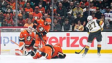 Obránce Vegas Shea Theodore posílá puk za Luká�e Dostála do brány Anaheimu.