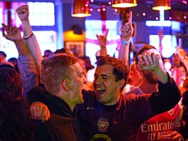 Fanou�ci Arsenalu v jedné z restaurací blízko Emirates Stadium sledují zápas...