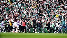 Fanou�ci skotského Celticu vnikají na trávník po záv�re�ném gólu v nastavení.