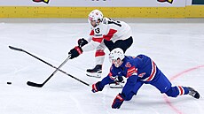 Nico Hischier ze �výcarska (vzadu) svádí souboj s Ameri�anem Masonem Lohreim.