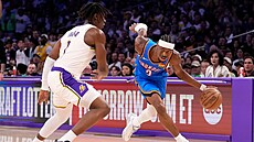 Shai Gilgeous-Alexander z Oklahomy obíhá s mí�em Adoua Thiera z Lakers.