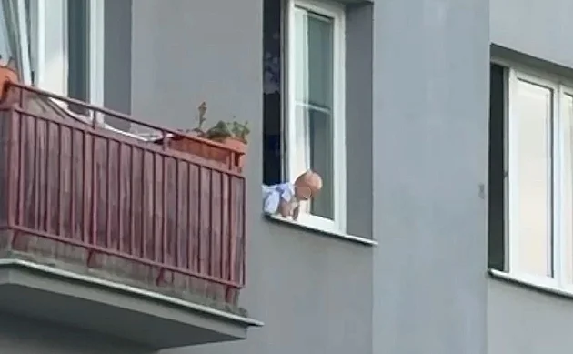 Batole sedělo v okně, zatímco matka spala. Muži pod ním hbitě roztáhli deku