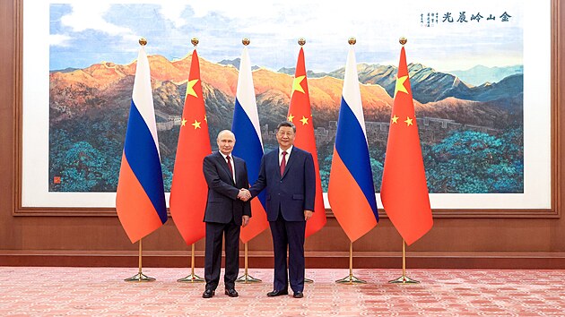 Rusk� prezident Vladimir Putin (vlevo) a ��nsk� prezident Si �in-pching (vpravo) si pod�vaj� ruce a p�zuj� pro fotografy b�hem sv�ho setk�n� v Pekingu. (20. kv�tna 2026)