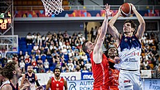 Milan Tomá� Strán�l z Basketu Brno se sna�í vyst�elit p�es bránícího Lubo�e...