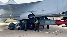 Ru�tí vojáci p�ipev�ují hypersonickou st�elu Kin�al na stíha�ku MiG-31 b�hem...