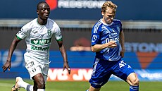 Olomoucký zálo�ník Michal Beran vyvá�í mí� p�ed Ousmanem Condém z Karviné.