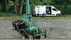 Zatímco obsluha s dálkovým ovládáním sedí na b�ehu, buldozer cestuje po dn�...