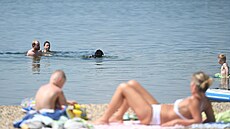 Teplo vylákalo lidi na první koupání v tomto roce. Zde na jeze�e Milada na...