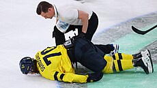 �védský úto�ník Oskar Sundqvist v pé�i léka�� po tvrdém st�etu s Timo Meierem.