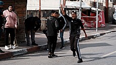 Palestinci házejí kameny na izraelská vojenská vozidla v okolí uprchlického...