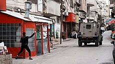 Palestinci házejí kameny na izraelská vojenská vozidla v okolí uprchlického...