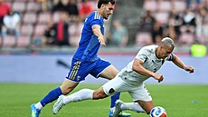 �eský obránce Tomá� Hole� padá v souboji s Fisnikem Asllanim z Kosova.