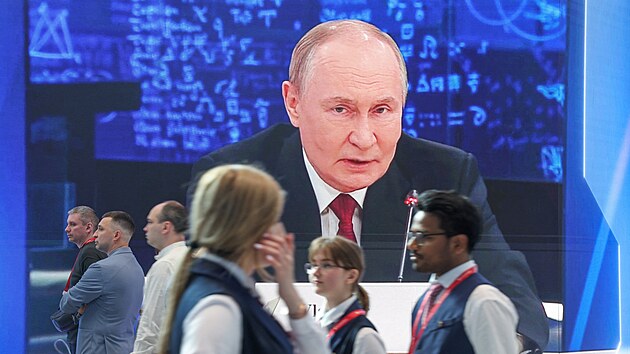 ��astn�ci proch�zej� kolem obrazovky s rusk�m prezidentem Vladimirem Putinem na Petrohradsk�m mezin�rodn�m ekonomick�m f�ru. (3. �ervna 2026)