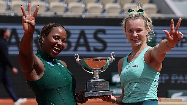 Kate�ina Siniakov� (vpravo) a Ameri�anka Taylor Townsendov� p�zuj� s trofej� pro v�t�zky �ty�hry na Roland Garros. Ukazuj�, �e je to pro n� t�et� spole�n� grandslamov� titul.
