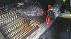 Hasi�i p�eh�átou baterii hybridního auta ochlazovali vysokotlakým proudem vody...