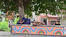 Mu� odpo�ívá ve stínu stromu b�hem horkého letního dne ve m�st� Prayagraj v...