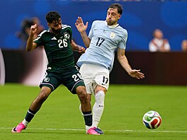 Matias Vina z Uruguaye v souboji o mí� s Abu Alshamatem ze Saudské Arábie.