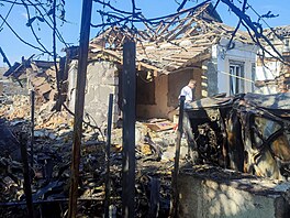 Civilista stojí na míst�, kde byl d�m t�ce po�kozen ruským dronovým útokem v...