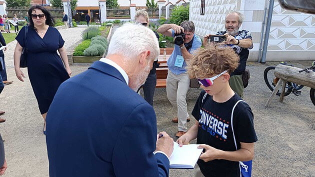 Po odchodu ze z�meck�ho are�lu ve Val�i, kde se konal tiskov� br�fink, �ekaly na prezidenta Petra Pavla i d�ti z m�stn� dru�iny. Prezidentsk� p�r se s nimi ochotn� fotil, z�jemc�m se i podepisoval. (17. �ervna 2026)