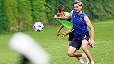 Obránce Karel Pojezný tahá v souboji o mí� zálo�níka Luká�e Dvo�á�ka.