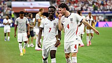 Bukayo Saka (vlevo) a Declan Rice spokojen� odcházejí z trávníku po výh�e nad...