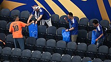U� tradi�ní obrázek po zápase japonských fotbalist�, fanou�ci hází odpadky do...