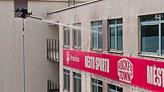 Dron umývá fasádu administrativní budovy hokejové arény v Pardubicích.