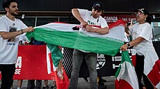 Mu� trhá vlajku Íránské islámské republiky p�ed utkáním na MS proti Novému...