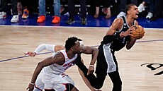 Victor Wembanyama (vpravo) ze San Antonio Spurs úto�í na ko� New York Knicks,...