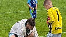 Branká� jabloneckých fotbalist� Jan Hanu� upravuje kopa�ku svému synovi...