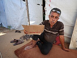 Palestinský uprchlík Náhid Hamúda se v letním vedru v Gaze ovívá kouskem...