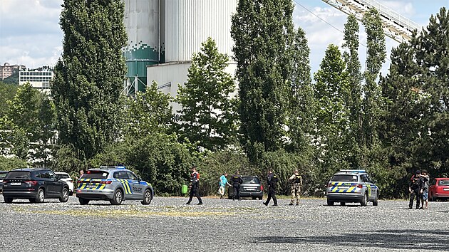 Policist� v pra�sk� Troji stoj� nedaleko vozidla, kter�m uj�d�l podez�el� mu� pohybuj�c� se se zbran� v ruce u �koly v �el�kovic�ch. (23. �ervna 2026)