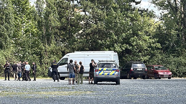 Policist� v pra�sk� Troji stoj� nedaleko vozidla, kter�m uj�d�l podez�el� mu� pohybuj�c� se se zbran� v ruce u �koly v �el�kovic�ch. (23. �ervna 2026)