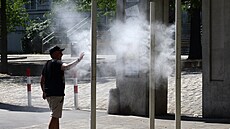 Mu� se ochlazuje pod ml�nou fontánou b�hem horkého letního dne v rakouské...