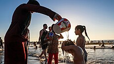 Palestinci se koupou ve St�edozemním mo�i u b�eh� m�sta Gaza. (19. �ervna 2026)