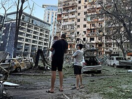 Obyvatelé stojí p�ed bytovým domem po�kozeným p�i ruském raketovém a dronovém...
