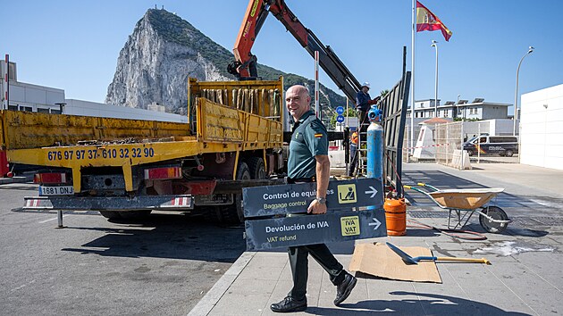 �pan�lsk� celn�k odn�� ceduli ze zru�en�ho kontroln�ho stanovi�t� mezi �pan�lskem a Gibraltarem. (6. �ervence 2026)