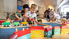 Chlapec na fotografii se no�í do sv�ta fantazie s d�ev�nými vlá�ky a kostkami v...