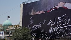 Lidé projí�dí kolem billboardu, na kterém je vyobrazen americký prezident...