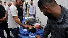 Lidé p�evá�ejí mrtvého Palestince po izraelském útoku u vesnice Till na...
