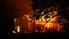 Z domu stoupá kou� a plameny kv�li lesnímu po�áru v Lege-Cap-Ferret (23....