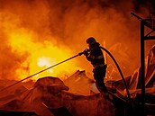 Hasi�i bojují s po�árem, který vznikl poté, co ruské rakety zasáhly sklad v...