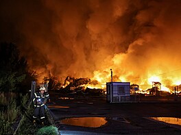 Hasi�i bojují s po�árem, který vznikl poté, co ruské rakety zasáhly sklad v...