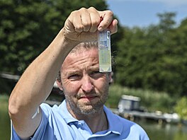 Kanály a jezera pokrývají koberce �as a sinic. V�dci odebírají vzorky kv�li...