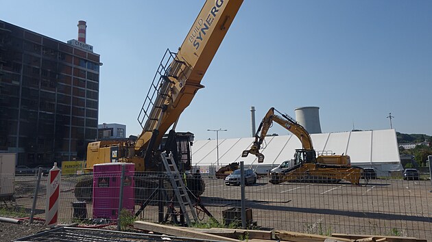 P��pravy na demolici vyho�el� budovy 34 fini�uj�. Kl��ov�m strojem bude ob�� demoli�n� bagr Caterpillar o provozn� hmotnosti kolem 100 tun, jeden z nejv�t��ch demoli�n�ch stroj� na sv�t�. (srpen 2026)