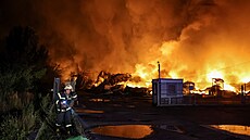 Hasi�i bojují s po�árem, který vznikl poté, co ruské rakety zasáhly sklad v...