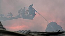 Hasi�i bojují s po�árem, který vznikl poté, co ruské rakety zasáhly sklad v...